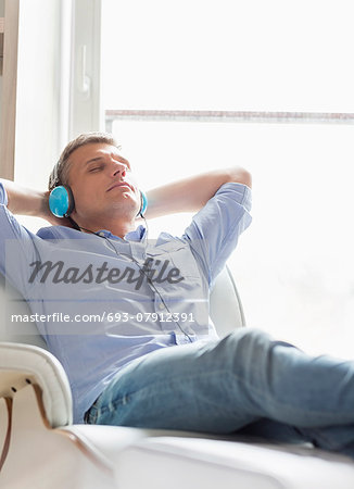 Relaxed Middle-aged man listening to music at home