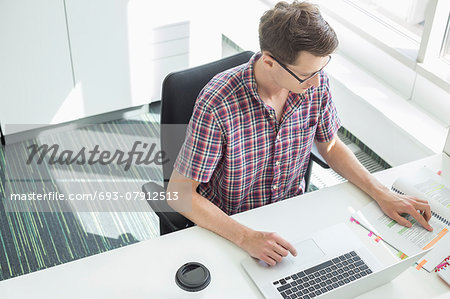 High angle view of creative businessman working at desk in office