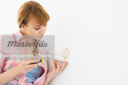 Woman working on electrical outlet