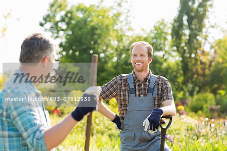 Happy gardeners talking at plant nursery