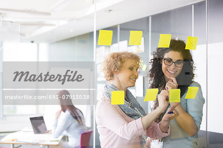 Business women brainstorming with sticky notes in office