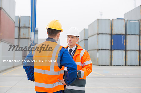 Workers conversing in shipping yard