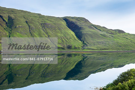 Mountain slopes reflected in the waters of a loch, Isle of Skye, Inner Hebrides, Highlands and Islands, Scotland, United Kingdom, Europe Mountain slopes reflected in the waters of a loch, Isle of Skye, Inner Hebrides, Highlands and Islands, Scotland, United Kingdom, Europe