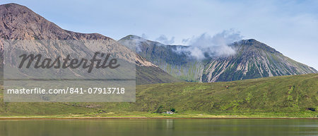 Small white solitary crofters cottage nestling below mountain range reflected in waters of the loch, Isle of Skye, Inner Hebrides, Highlands and Islands, Scotland, United Kingdom, Europe Small white solitary crofters cottage nestling below mountain range reflected in waters of the loch, Isle of Skye, Inner Hebrides, Highlands and Islands, Scotland, United Kingdom, Europe