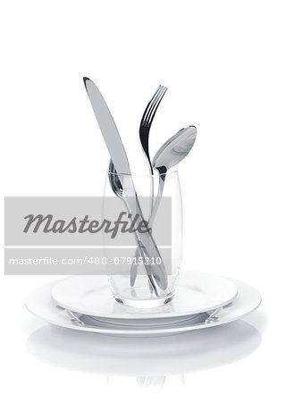 Silverware or flatware set in glass over plates. Isolated on white background