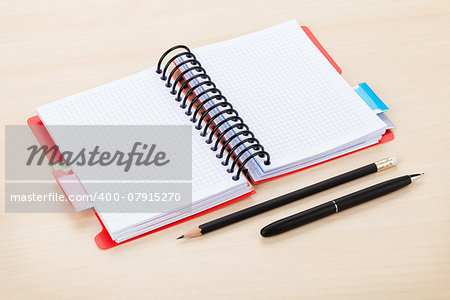 Office table with blank notepad, pen and pencil. View from above with copy space