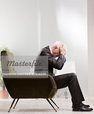 business man holding his head with his hands because of his negative feelings