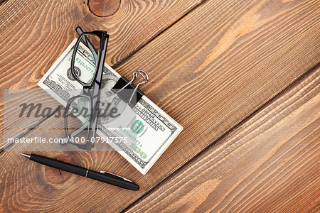 Money cash, glasses and pen on wooden table with copy space