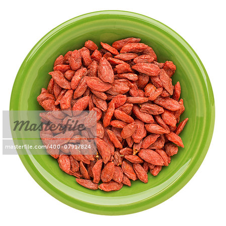 dried goji berries on an isolated green ceramic bowl - superfood abstract