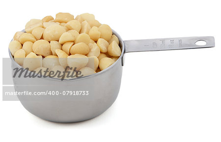 Macadamia nuts in an American cup measure, isolated on a white background