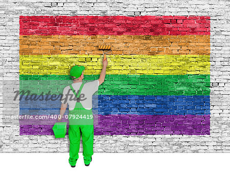 House painter covers white brick wall with rainbow flag