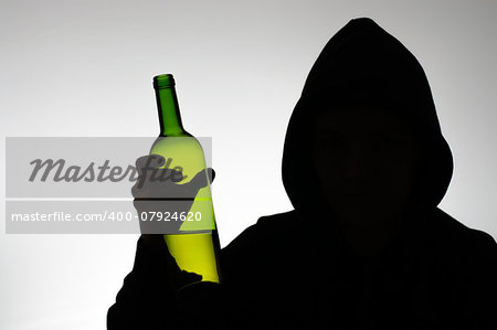 Silhouette of hooded anonymous alcoholic with a wine bottle
