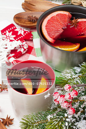 Christmas mulled wine on wooden table with fir tree and decor