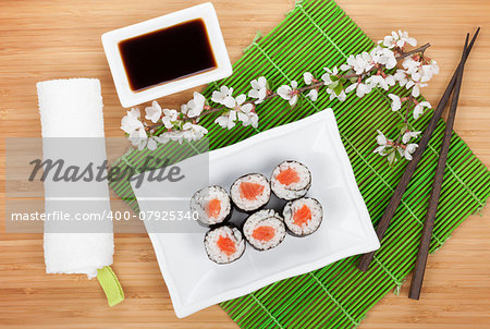 Sushi maki set and sakura branch on bamboo table