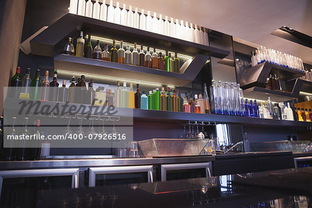 Close up on bar with bottle in a line at the nightclub