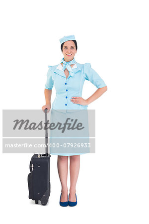 Pretty air hostess holding suitcase on white background