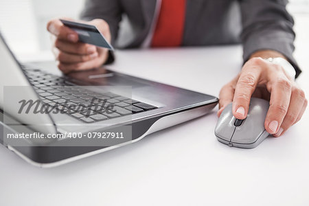 Businessman shopping online on laptop in his office