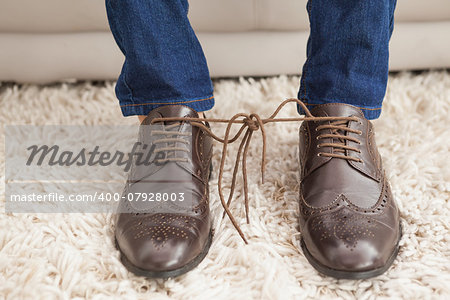 Classy mans shoelaces tied together at home in the living room