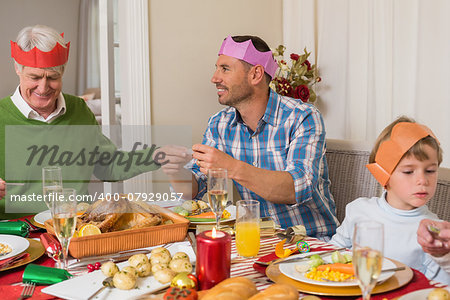 Family reading paper in party hat at home in the living room