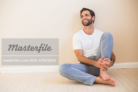 Happy man sitting on floor in his new home
