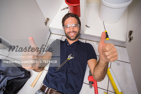 Plumber fixing under the sink in the kitchen