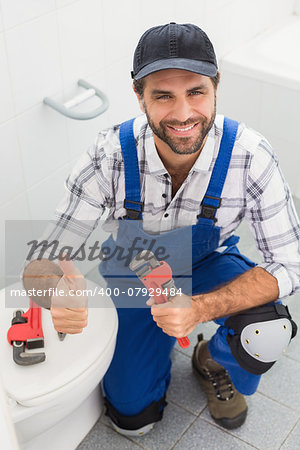 Plumber smiling at the camera in the bathroom