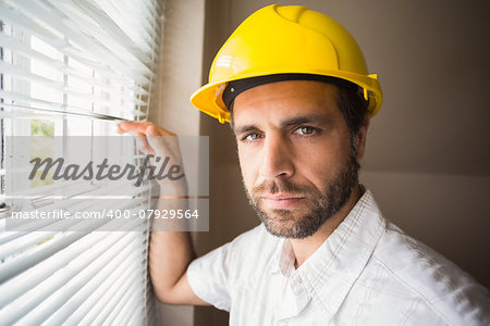 Handyman looking out the window in a new house