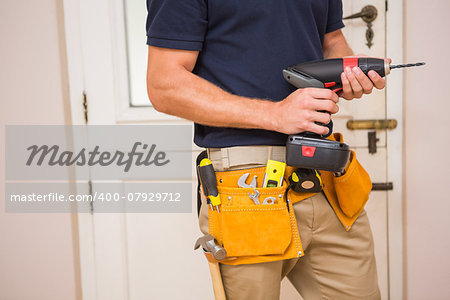 Construction worker drilling hole in wall in a new house