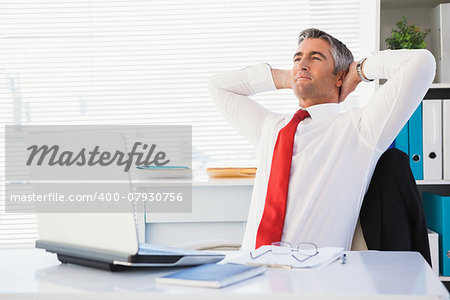 Relaxed businessman sitting and relaxing in his office