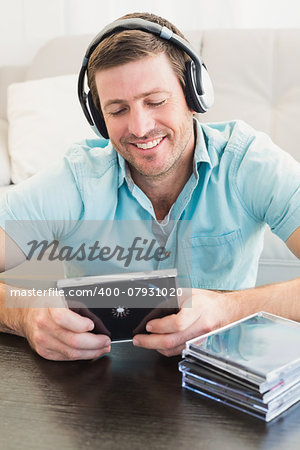 A man listening to cds at home in the living room