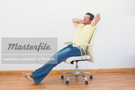 A man leaning back in swivel chair at home in the living room