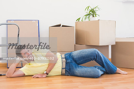 Happy man posing with moving boxes at home in the living room