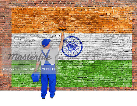 House painter covers old  brick wall with flag of India