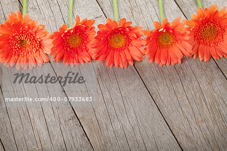 Wooden background with orange gerbera flowers and copy space