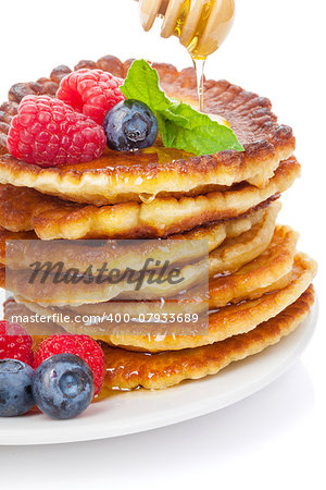 Pancakes with raspberry, blueberry, mint and honey syrup. Isolated on white background