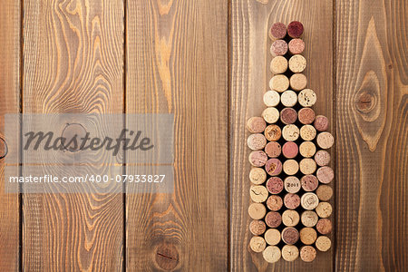 Wine bottle shaped corks over rustic wooden table background. View from above with copy space