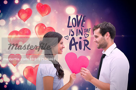 Pretty brunette giving boyfriend her heart against valentines heart design