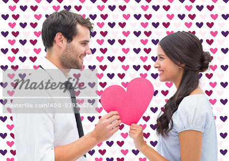 Pretty brunette giving boyfriend her heart against valentines day pattern