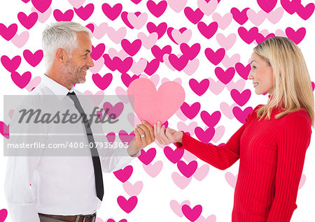 Handsome man getting a heart card form wife against valentines day pattern