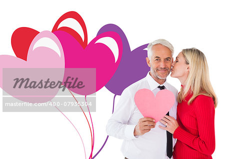 Handsome man holding paper heart getting a kiss from wife against valentines love hearts