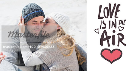 Attractive couple on the beach in warm clothing against love is in the air