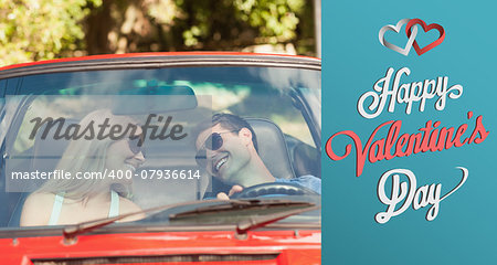 Loving couple in their red cabriolet having a ride against cute valentines message