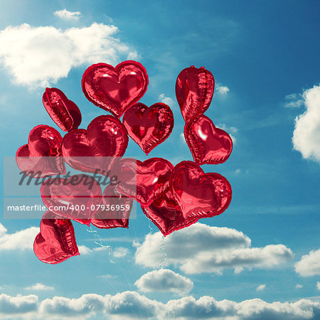 Heart balloons against sky and clouds
