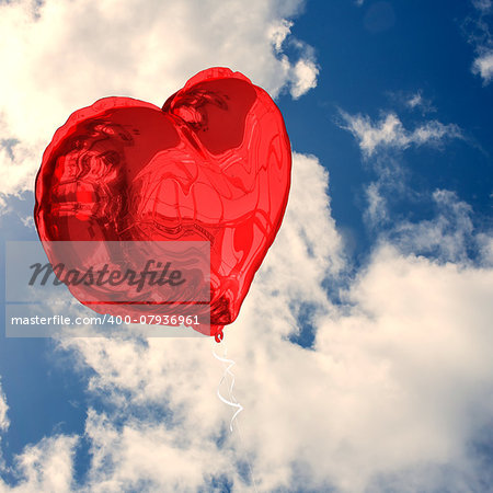 Red heart balloon against bright blue sky with clouds