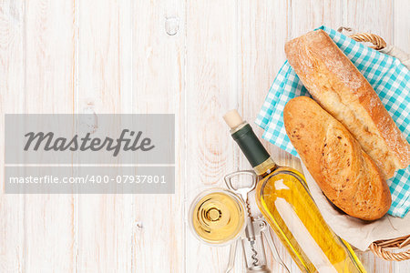 White wine and bread on white wooden table background with copy space