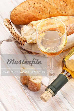 White wine and bread on white wooden table