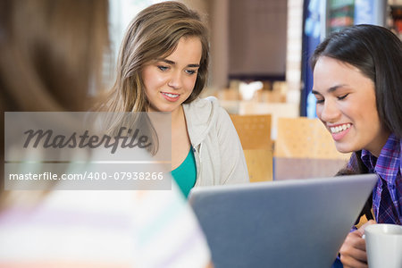 Young students doing assignment on laptop together at the university