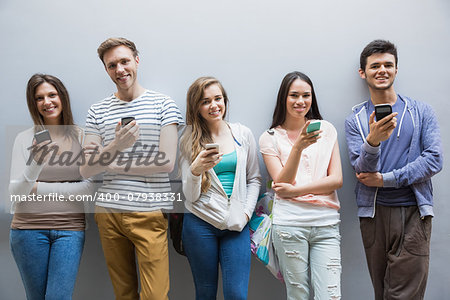 Students using their smartphones in a row at the university