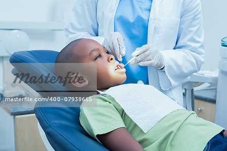 Side view of boy having his teeth examined by a dentist