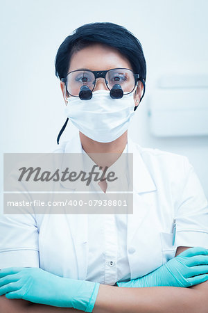 Portrait of female dentist wearing surgical mask and dental loupes